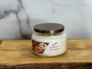 Jar of Cashmere Pumpkin candle on a wooden surface with a marble background Jar of Cashmere Pumpkin candle on a wooden surface with a marble background