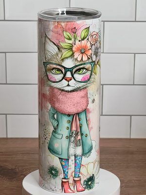 Tumbler with a cat illustration wearing glasses, a coat, and scarf on a white tile background. Tumbler with a cat illustration wearing glasses, a coat, and scarf on a white tile background.