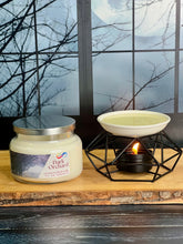 Load image into Gallery viewer, Candle and candle warmer on a wooden surface with a window view of trees and sky.