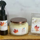 Three scented products with autumn-themed labels on a wooden surface.
