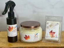 Load image into Gallery viewer, Three scented products with autumn-themed labels on a wooden surface.
