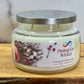 Candle jar labeled 'Pining for Winter' on a wooden surface with a white background