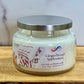 Jar of 'Gingerbread Applesauce' candle with a decorative label on a wooden surface.