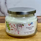 Jar of 'Peppermint Twist' candle with a silver lid on a wooden surface.