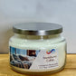 Jar candle labeled 'Snowberry Cabin' on a wooden surface with a white background