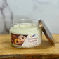 Cashmere Pumpkin candle in a glass jar with a metal lid on a wooden surface.