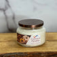 Jar of Cashmere Pumpkin candle on a wooden surface with a marble background