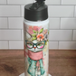 Thermos with a cat design on a white pedestal against a tiled wall.