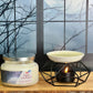 Candle labeled 'Dark Orchard' and a ceramic oil burner with a lit candle on a wooden surface.