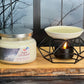 Jar of 'Dark Orchard' candle with a lit wax warmer on a wooden surface.