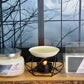 Candle and wax melts with packaging on a wooden surface in front of a window with bare trees.