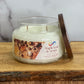 Candle with a 'Maple Leaf & Acorn' label on a wooden surface