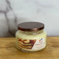 Jar of 'Maple Walnut Pancake' candle on a wooden surface with a marble background