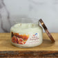 Sassy Pumpkin candle in a glass jar on a wooden surface with a marble background