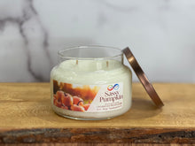 Load image into Gallery viewer, Sassy Pumpkin candle in a glass jar on a wooden surface with a marble background
