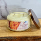 Jar candle labeled 'Sweet Potato Souffle' on a wooden surface with a marble background