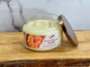 Jar candle labeled 'Sweet Potato Souffle' on a wooden surface with a marble background