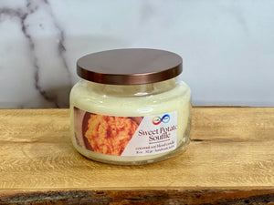 Jar of Sweet Potato Souffle candle on a wooden surface with a marble background